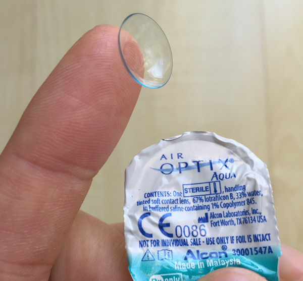 Die Air Optix Aqua Kontaktlinse von Alcon am Finger